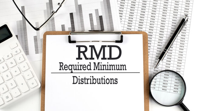 Paper with RMD Required Minimum Distributions on a chart with calculator,pen and magnifier Secure Act 2.0: Changes to Required Minimum Distribution Start Dates