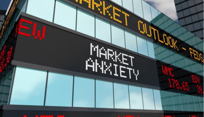 market A digital stock ticker display on a building showing 'Market Anxiety' and 'Market Outlook' in a city setting